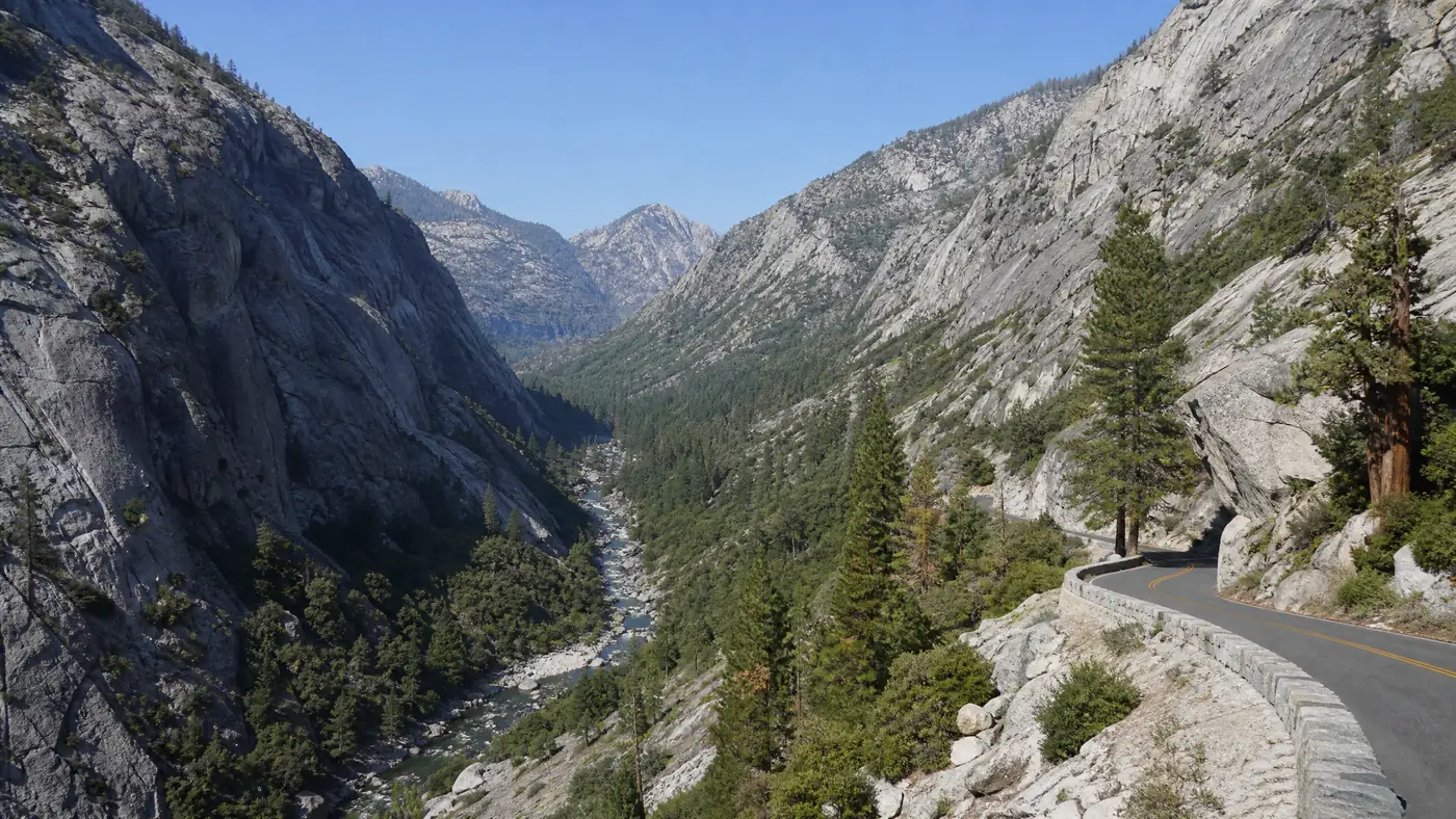 A mountain road dropping into a deep granite canyon